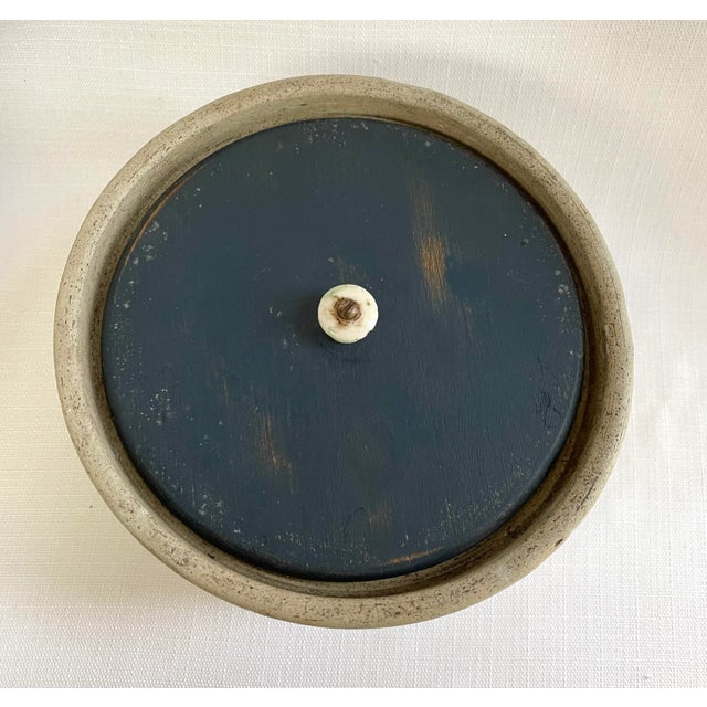 This antique American stoneware butter crock has nice blue floral stenciled detailing. Unsure if wood lid is original.