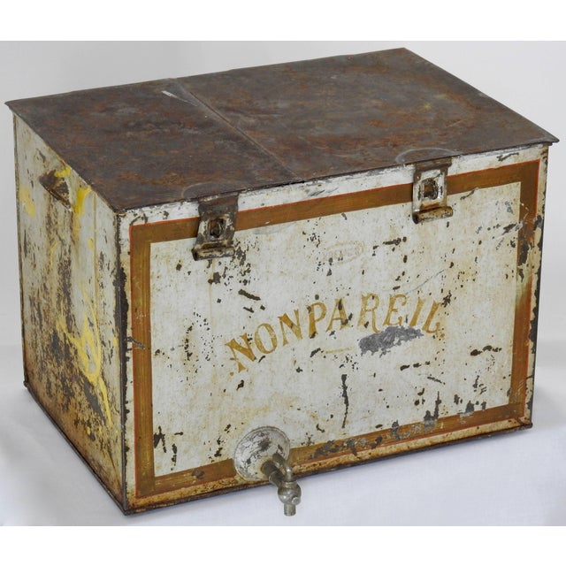 Rustic French Non Pareil metal ice bin has a hinged top along with a drain spout near the bottom. Made of galvanized...