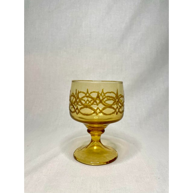 There's Mid Century Modern vibe amongst these amber gold colored glass goblets. The set of 8 consists intricate scroll-...