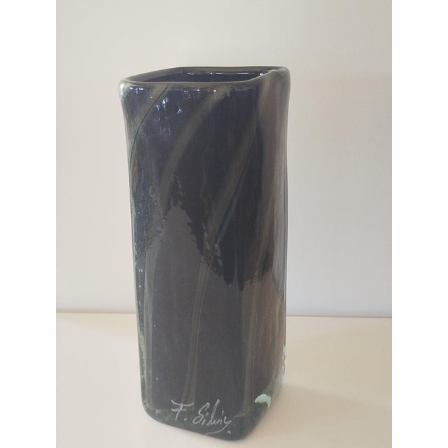 A cubic vase in hand-blown glass, entirely composed of three layers of glass, hence its opacity and weight. Deep black,...