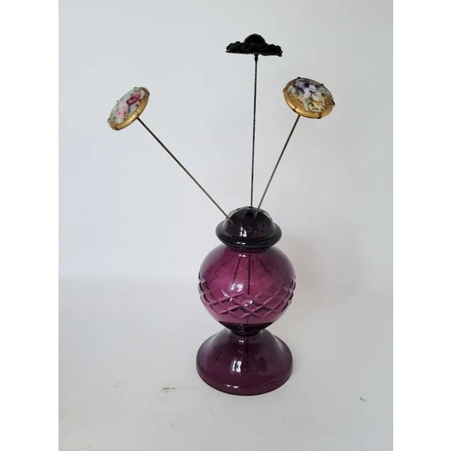A striking pair of antique amethyst cut glass hatpin holders dating to the turn of the 20th century. Each vessel is blown...