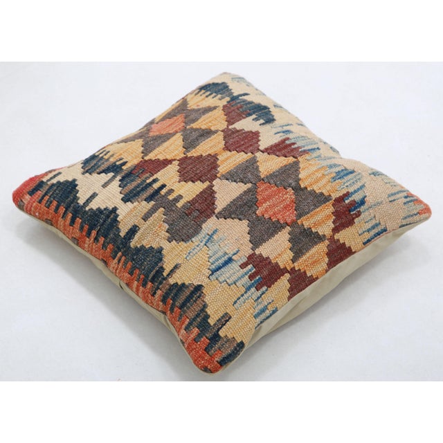 A one-of-a-kind handwoven Afghan wool kilim accent pillow featuring diamond lattice with ikat bands. Cut and sewn by hand...