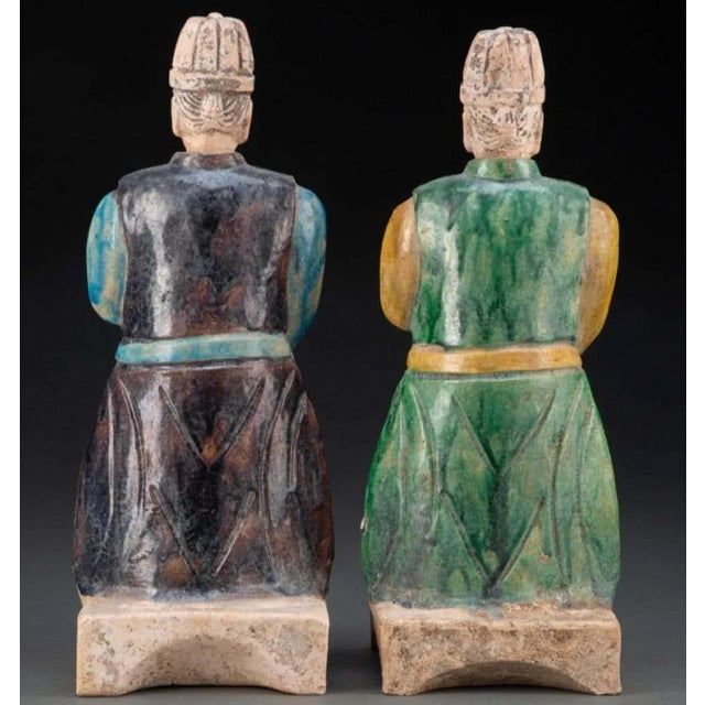 A pair of Chinese Ming Dynasty glazed earthenware figure of Attendant. The condition of these 5 century old glazed pottery...