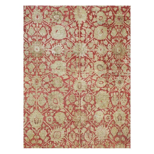 This early 20th-century Persian Tabriz rug presents a richly patterned allover floral composition across a warm red field....