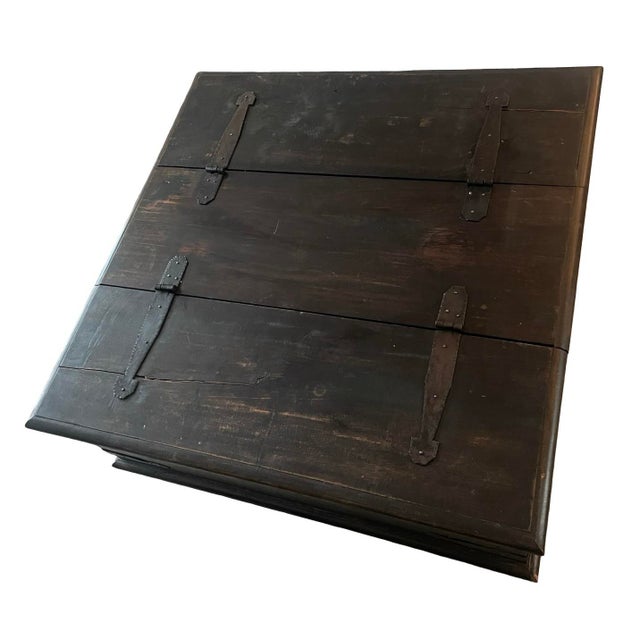 Character-rich solid wood trunk repurposed as a coffee table. Hand-forged–style black iron strap hinges, side ring...