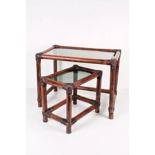 Beautiful mid-century dark brown bamboo stacking tables with a smoked glass table top.