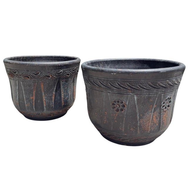 A pair of vintage Azteca terracotta planters finished in a distressed blackwashed finish that reveals the natural...