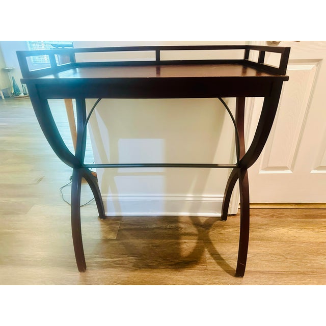 Sophisticated and functional, this mahogany drinks table features elegant curule-style legs and a non-removable top tray....