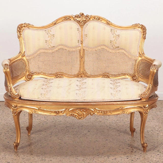 A giltwood and carved French Louis XV style settee in original gilt finish. Circa 1900