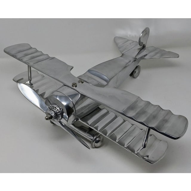 This sparkling polished aluminum art deco model airplane sculpture with moving landing gears, wheels, and propellers would...