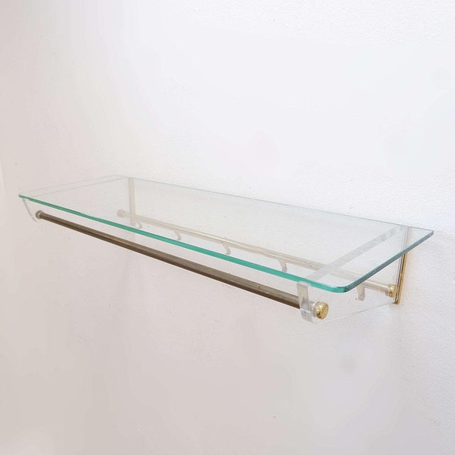 Measures : 85x32,5cm H:14cm Materials : Glass - Brass - acrylic Wall-mounted coat rack in glass (top shelf), acrylic...