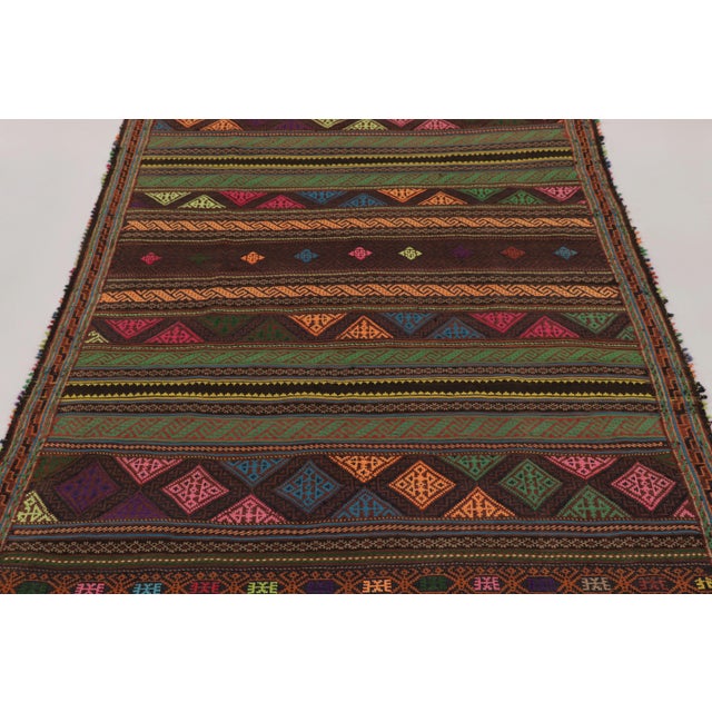Made with handwoven wool circa 1950-1960, this 5x7 vintage Persian Kilim, originating from the Larkhabi region of...