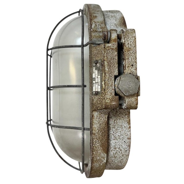 Industrial wall light made by Elektrosvit in former Czechoslovakia during the 1960s. It features a cast iron body, a milk...