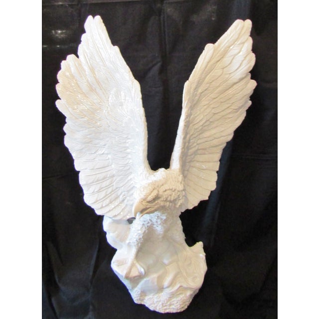 This Italian white glazed terra cotta eagle sculpture from the 1960s is a monumental piece that stands at 35.5 inches tall...