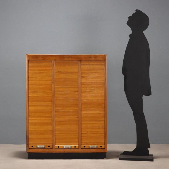 Storage unit, with internal shelves, shutter openings, walnut veneer and Formica top, aluminum handles. This piece is...
