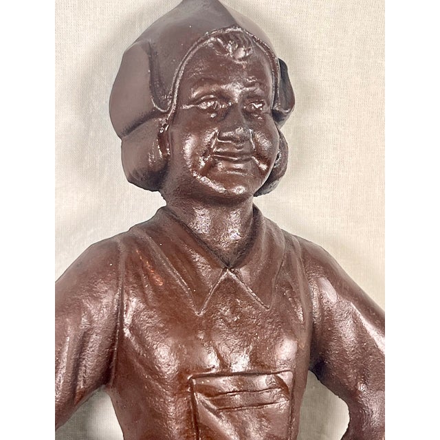 A charming pair of antique figural cast iron statues representing a traditional Dutch boy and girl, manufactured in the...