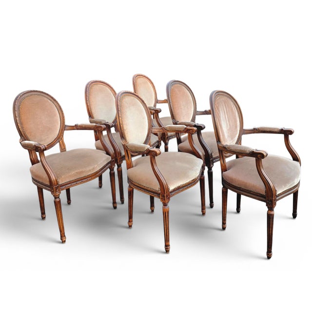 This Set of Six Louis XVI Revival Walnut Dining armchairs by W. & J. Sloane, with woven oval, neutral-toned upholstered...