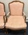 Elegant pair of French Louis XV–style carved armchairs featuring gracefully shaped walnut-toned frames with ornate floral...
