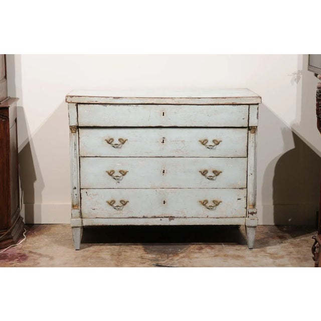 This exquisite 19th Century Painted French Empire Period 4 Drawer Commode in Pale Blue is a true testament to the elegance...