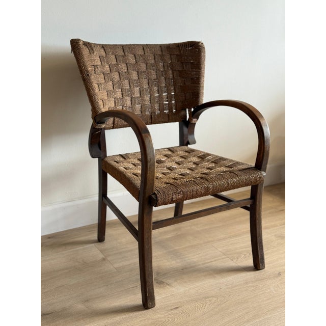 This striking Art Deco chair features a curved bentwood frame with distinctive rounded armrests and clean geometric lines...