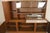 Large two piece bookcase with bottom cabinet. Glass front top cabinet with drop down bar storage. Base features two...