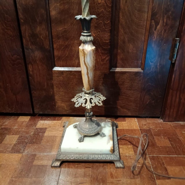 Antique lamp with ornate metal work and marble/stone accents. Does have a lampshade that is not original. In good antique...