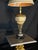 A vintage-style ornate table lamp featuring a warm gold-toned glass body, intricate decorative patterning, antique bronze-...