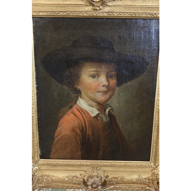 Portrait of a child with a hat, dating from the first half of the 19th century, in its original gilt frame. The painting...