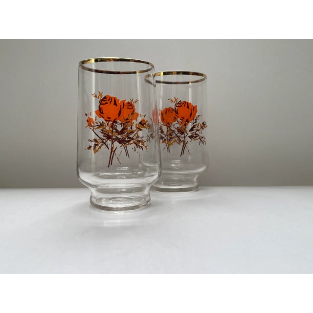 A beautiful pair of stylized rose printed gold trimmed juice glasses made by the Libbey Glass Company in the mid 20th...