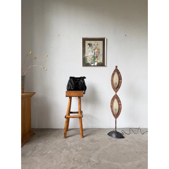 Antique floor lamp with a black patinated hammered bronze base and a tall stem supporting two light sources with galalith...