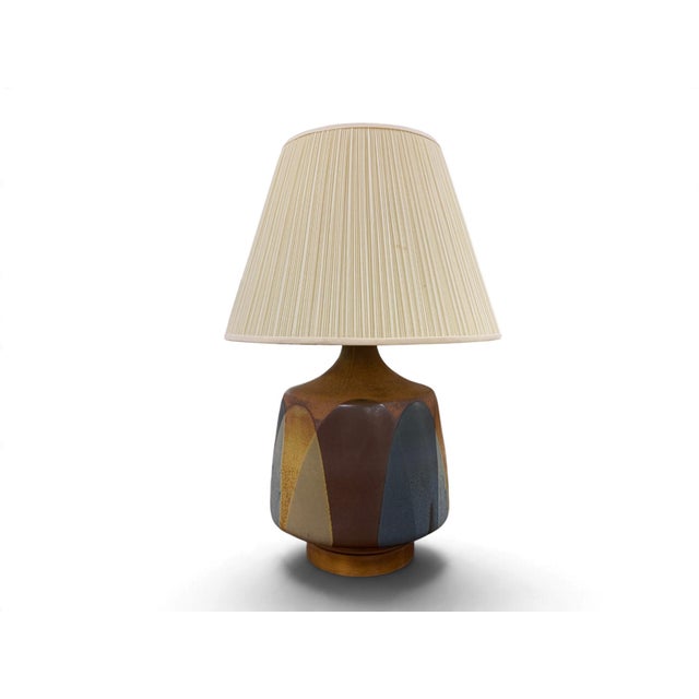 A vintage David Cressey Terracotta Table Lamp on a wooden base with orange, blue, brown, and green glaze. Circa 1960's,...