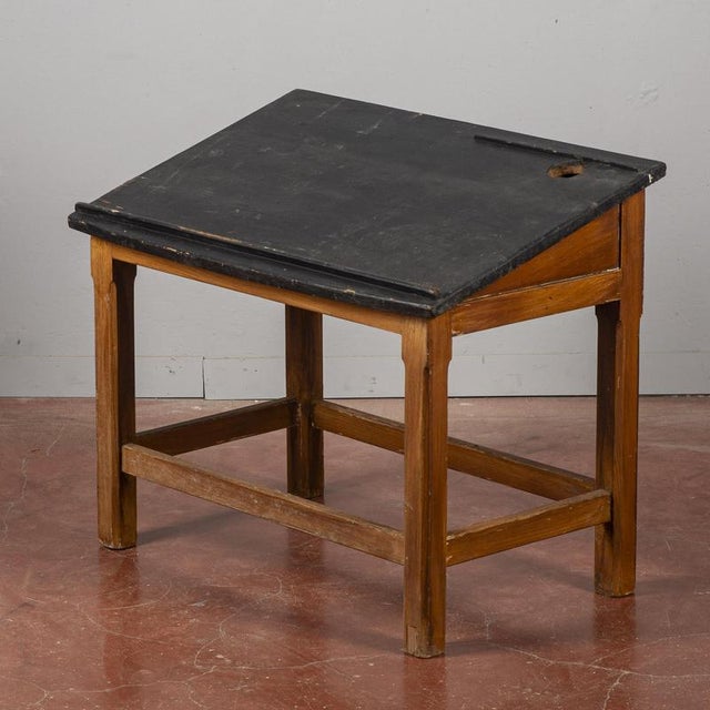 This vintage student desk captures the essence of mid-20th-century school furniture. Crafted from solid wood, the piece...