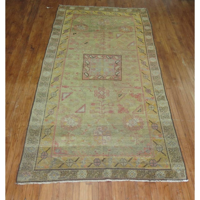 Antique Khotan rug with soft green field. Measures: 5'2" x 10'8" Khotan rugs were produced in Eastern Turkestan. Khotan...