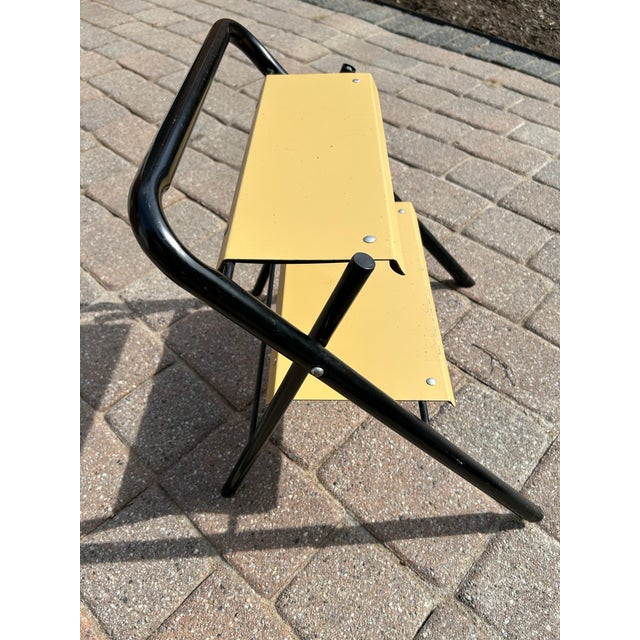 This a MCM folding metal step stool. It is probably made of steel, due its weight and it does react positively to a magnet...