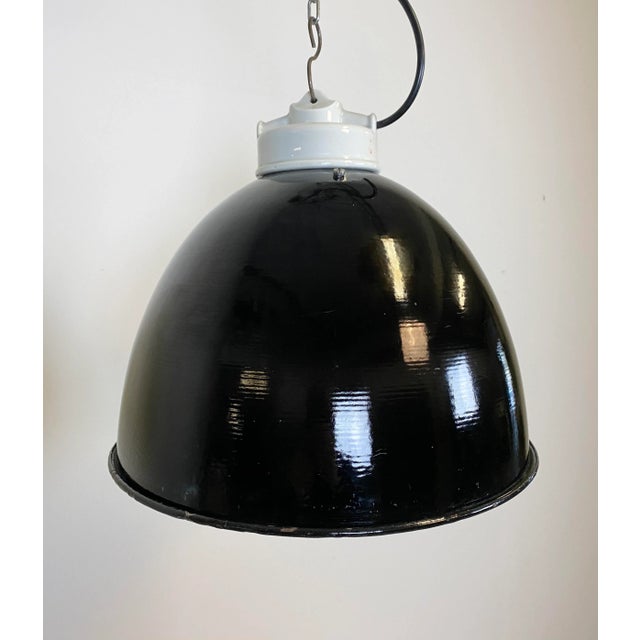 - Industrial lamp made during the 1950s - Black enamel shade, white enamel interior - Porcelain top with glass cover -...