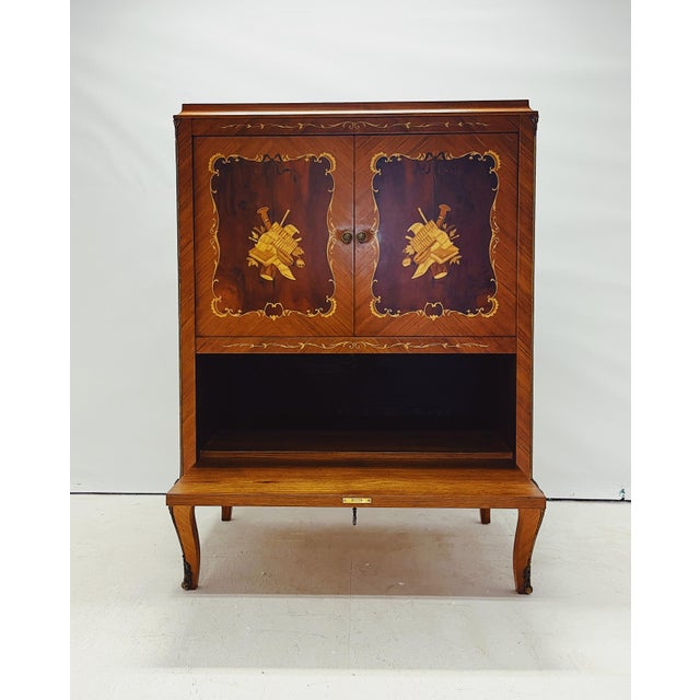 Classic TV cabinet with an elegant appearance, likely in the style of an 18th- or 19th-century European marquetry cabinet....