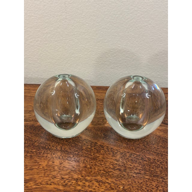 A striking pair of vintage 1960s Swedish hand-blown glass bud vases. Each features a compact spherical form in thick clear...