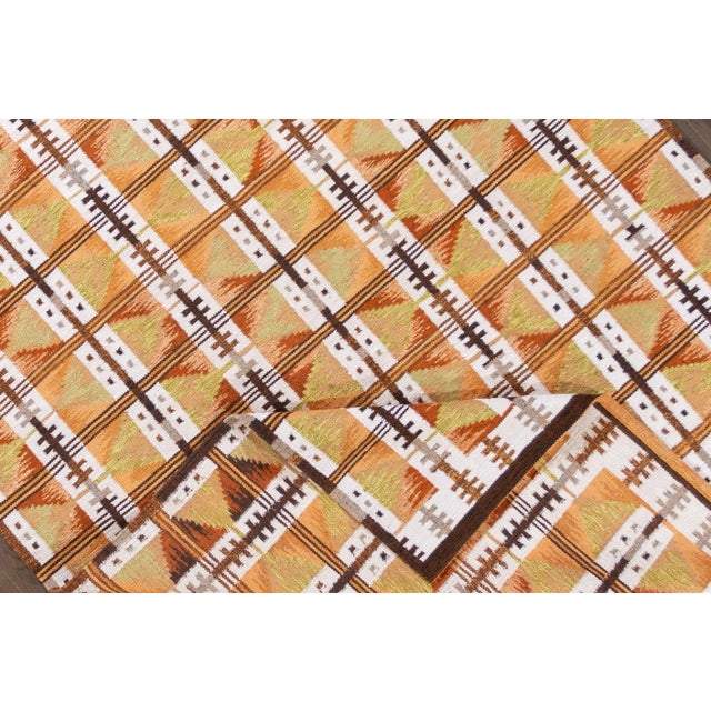 A 21st-century modern Scandinavian-style rug in an all-over orange geometric pattern. This rug measures at 9' x 12'3".