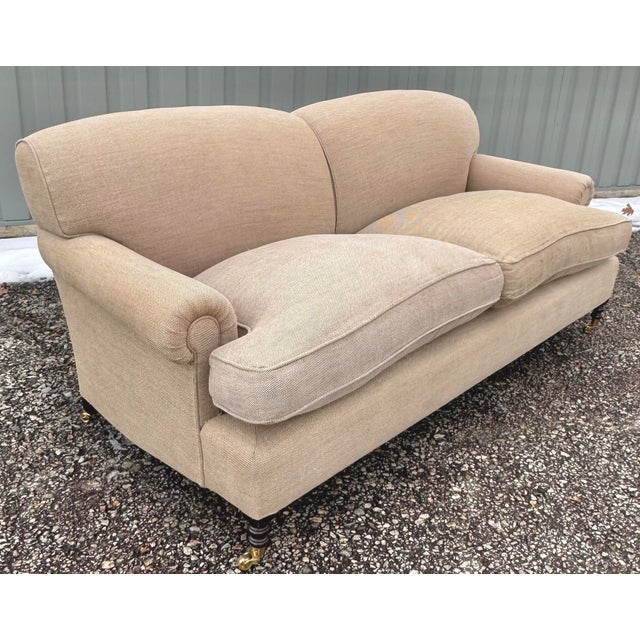 George Smith Short Scroll Arm Sofa in flax linen with down seat cushions on turned legs with brass casters.