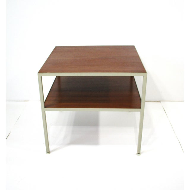 A walnut and cream metal squared tubed framed double tiered side table in the manner of George Nelson . The well grained...