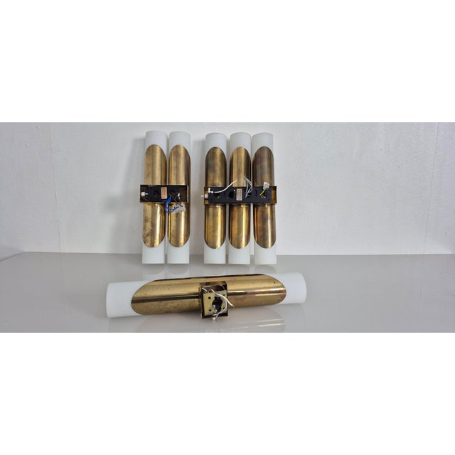 Set of 3 wall lamps (1/2/3) in brass and opal glass from the 1960s. Widths: 6/12/18 cm. Each glass shade contains 2 light...