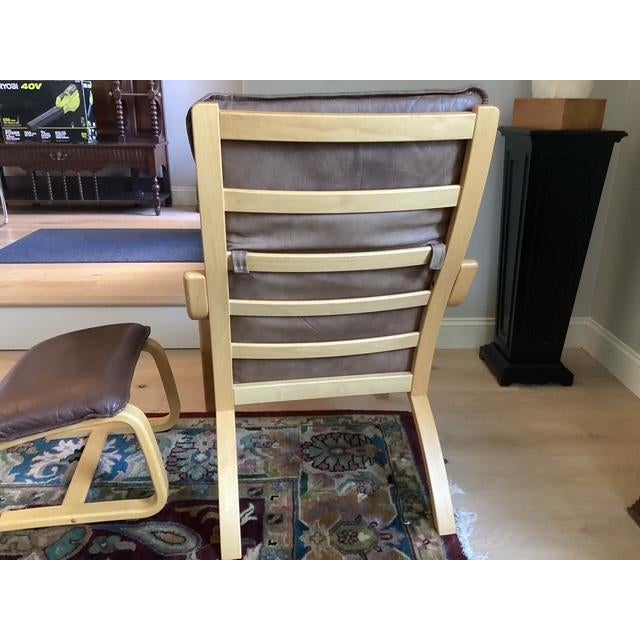 A pair of vintage mid-century Danish modern leather and bentwood beech armchairs and ottomans manufactured by Stouby...