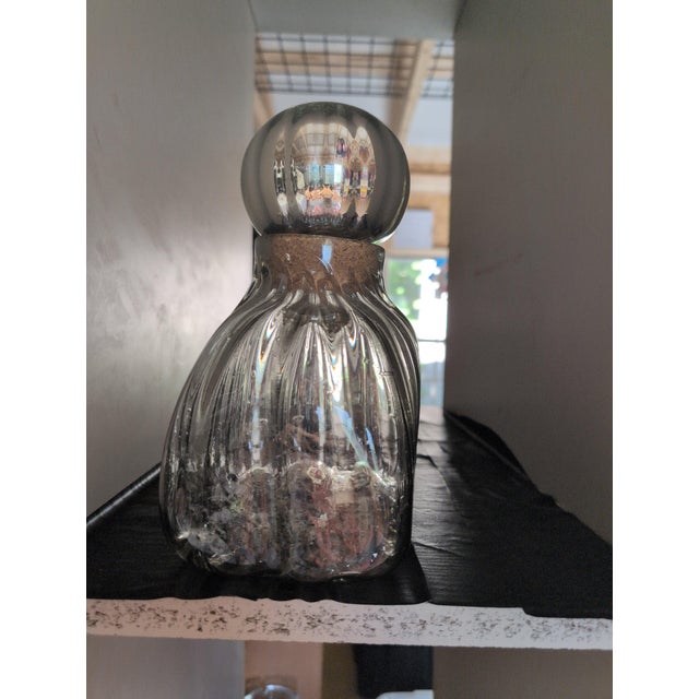Vintage glass decanter featuring a cork stopper and elegant ribbed design. • Clear glass with a ribbed texture • Round...