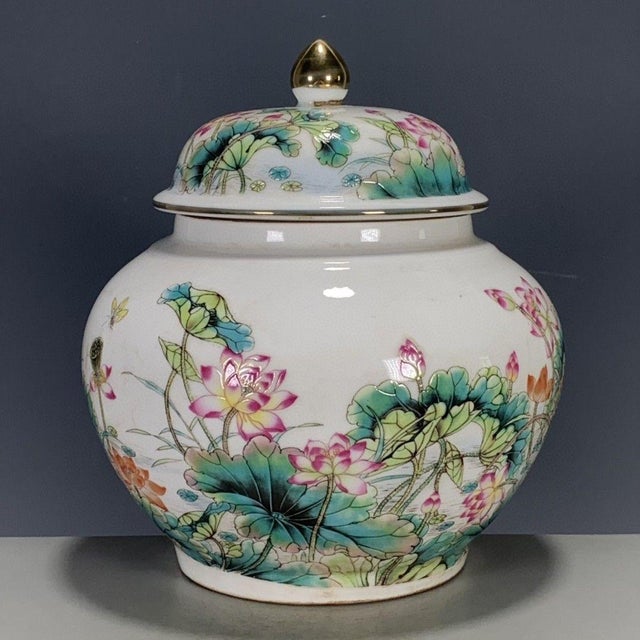 A beautiful Chinese Famille Rose porcelain covered jar. The white ground is finely hand-painted with a vibrant scene of...