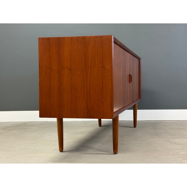 A mid century modern teak sideboard credenza with tambour doors designed by Svend Aage Larsen for Faarup Møbelfabrik....