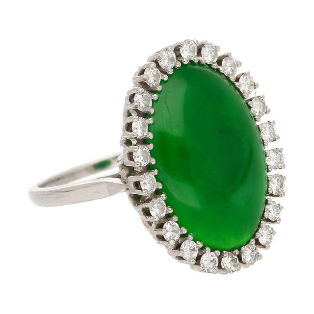 This stunning antique ring features a richly saturated old mine Jadeite Jade cabochon framed by 22 bright round diamonds...