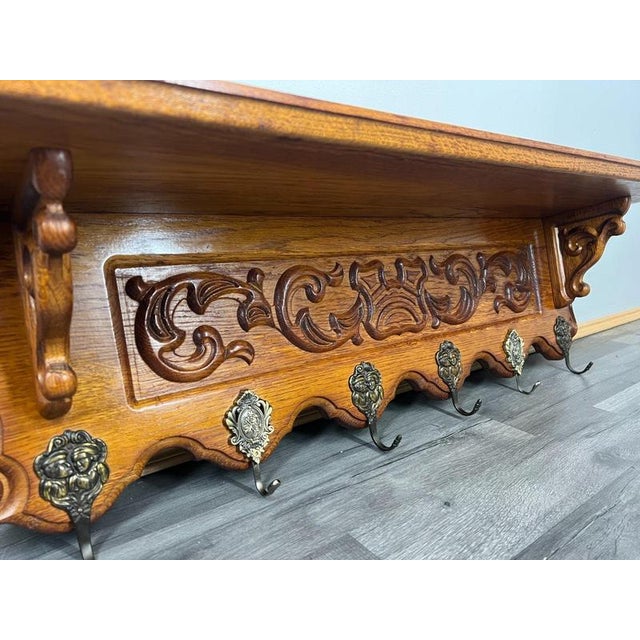 A beautifully crafted Vintage French wall-mounted coat hanger , made from warm oak and richly detailed with ornate carved...