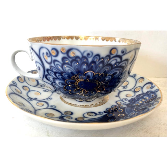 This Russian cup and saucer have been hand painted with swirls of blue with gold accents.