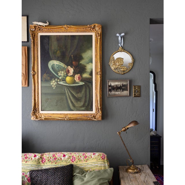 This round, early 20th-century cast brass Art Nouveau mirror depicts a female in profile among flowers and leaves with...