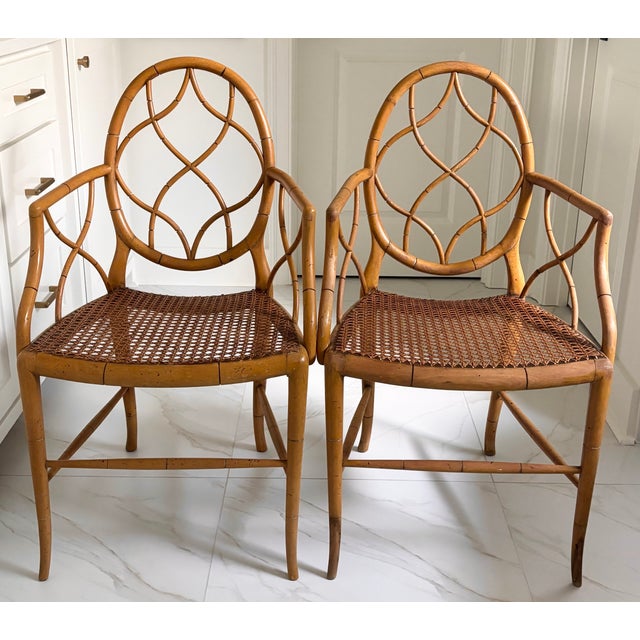 A stylish pair of bespoke English faux bamboo armchairs that feature oval backs with intricate interlaced latticework...